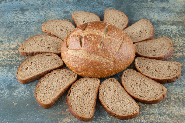 大理石の背景にスライスと新鮮な茶色のパン.高品質の写真 - 写真・画像
