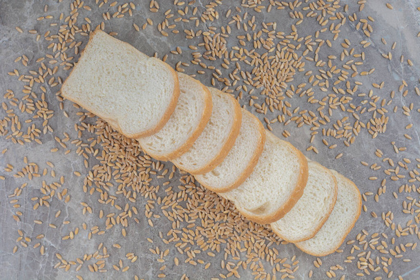 大理石の背景にオート麦の穀物とスライストーストパンのセット.高品質の写真 - 写真・画像