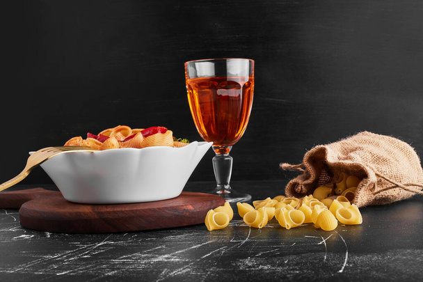 smakelijke pasta met wijn op een donkere achtergrond - Foto, afbeelding