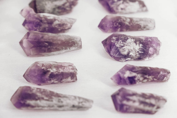Piedras de amatista púrpura sobre un fondo blanco. Copiar, espacio vacío para texto. - Foto, Imagen