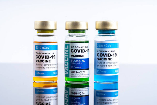 Laboratuvar tezgahında Covid-19 aşısı bulunan tıbbi konsept ampulleri veya şişeleri - Fotoğraf, Görsel