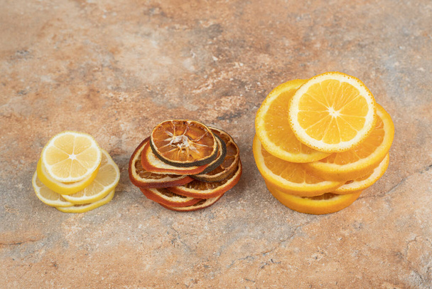 Свежие и сушеные ломтики лимона на мраморном фоне. Высокое качество фото - Фото, изображение