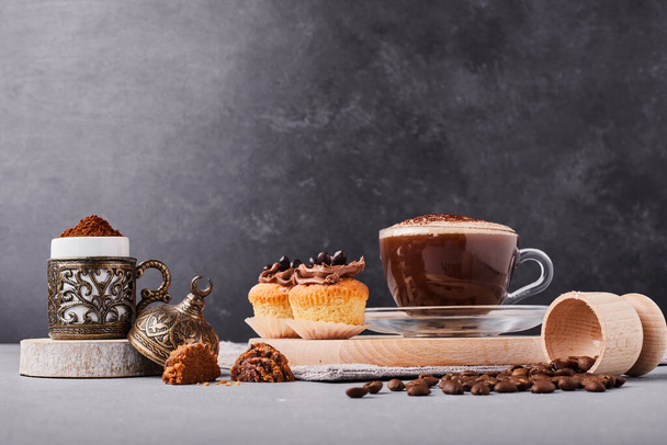 cup of tasty coffee and cupcakes on the table background - Photo, Image