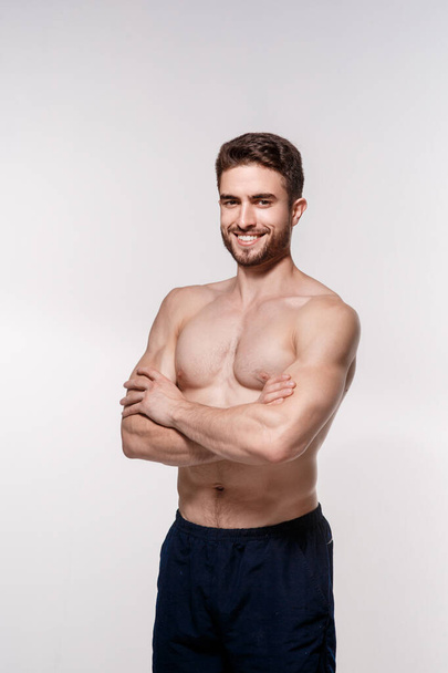 athletic man on a white background. handsome bearded athlete looking forward. - Фото, изображение