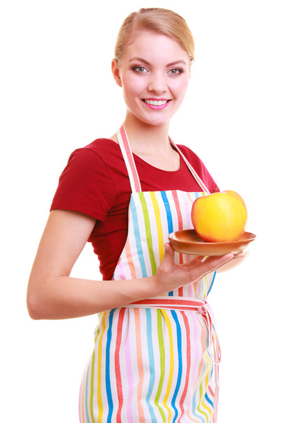 Happy housewife or chef in kitchen apron offering apple isolated - Foto, Bild