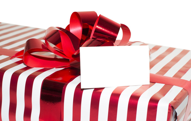 Рождественский подарок с лентой и биркой. Изолированные на белом фоне
 - Фото, изображение