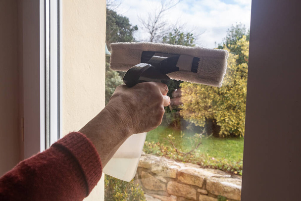 Pour laver la fenêtre d'une porte avec un grattoir - Photo, image