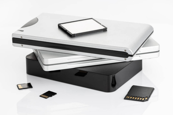 Haufen externer Festplatten auf weißem Tisch. Festplatten-Datenspeicherkonzept - Foto, Bild