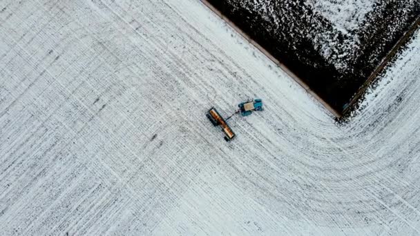 Landwirt überprüft Füllmenge des Trockendüngerstreuers auf Winterweizen und Gerste auf schneebedecktem Feld - Filmmaterial, Video