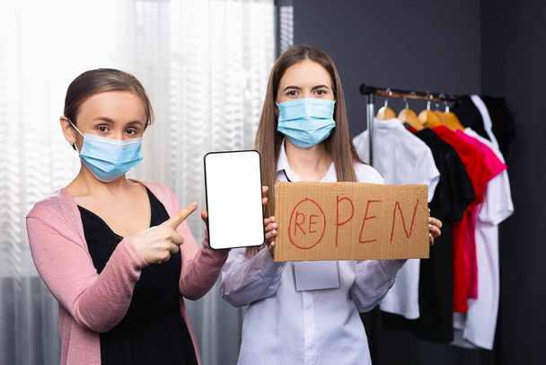 Reopen store concept after the coronavirus pandemic. Please wear a face mask and keep your distance to protect from Covid-19. Forefinger to mock up device screen - Fotó, kép