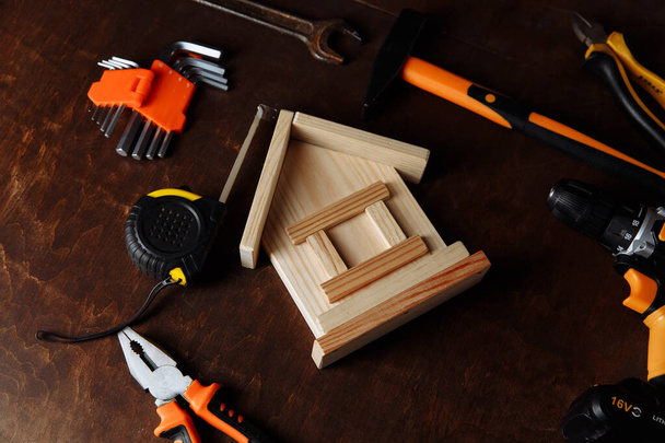 様々な修理ツールや家のモデル。木製の背景に修復ツールキット - 写真・画像