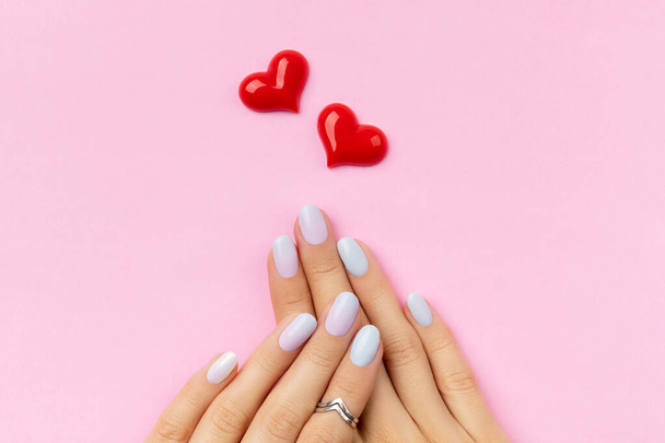 Womans hands with trendy manicure on pink background. Summer nail design - Photo, Image