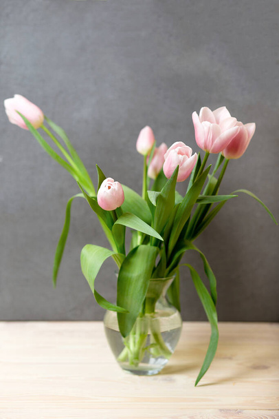 Composizione accogliente di primavera di tulipani rosa in vaso su tavolo, spazio di copia, giorno delle donne internazionale. Tulipano bouquet concetto - Foto, immagini