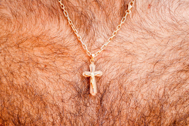 goldenes Kreuz mit Kette. Männerhals. Körperbehaarung - Foto, Bild