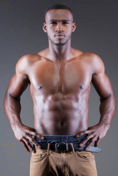 Ciemnoskóry mężczyzna fitness model na szarym tle - Zdjęcie, obraz