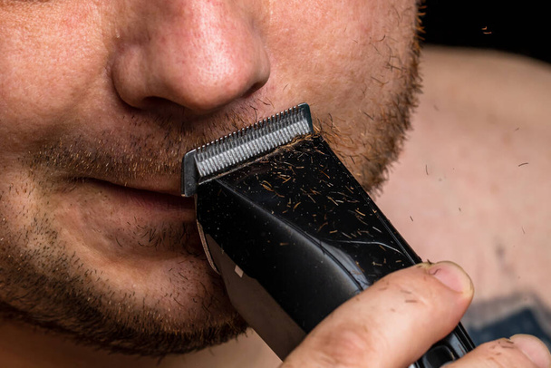 Muž holení nebo zastřihování vousů pomocí střihače vlasů - Fotografie, Obrázek