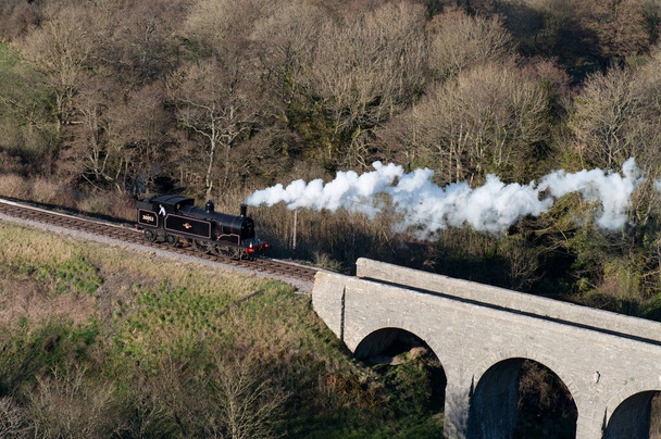 a solitary steam locomotive crosses a railway viaduct on the Swanage heritage railway - Photo, Image