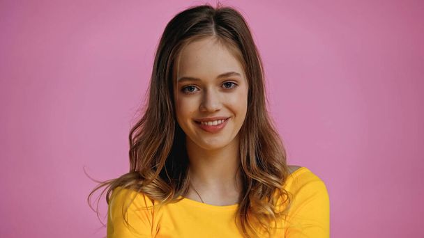 cheerful teenage girl looking at camera isolated on pink  - Foto, Imagem