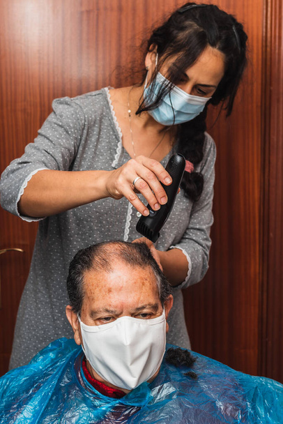 Hija cortando el pelo de su padre en casa - Foto, Imagen