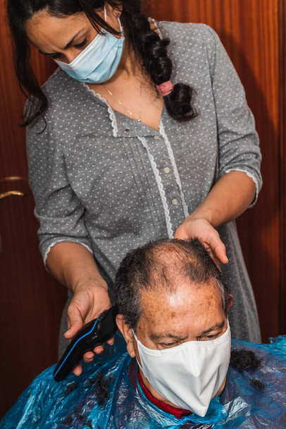 Hija cortando el pelo de su padre en casa - Foto, Imagen