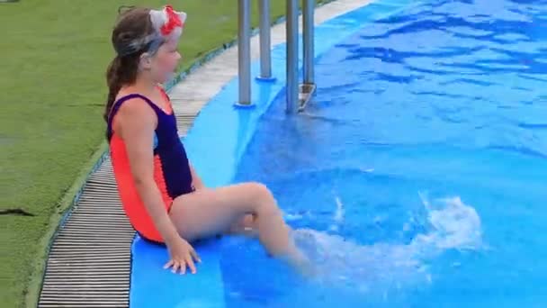 Ein Kind in Badeanzug und Wassermaske schwimmt im Pool des Wasserparks. - Filmmaterial, Video
