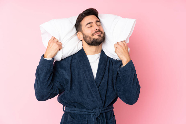 Young man going to sleep isolated on pink background - Foto, immagini