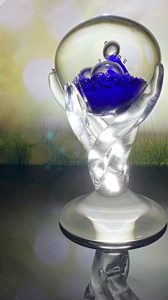 Osvětlený křišťálový pohár stojí na skle můžete vidět na pozadí - Fotografie, Obrázek