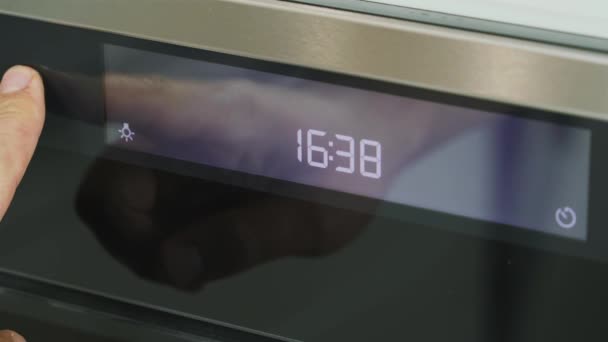 El hombre cocina establece la temperatura para hornear en el horno - Metraje, vídeo