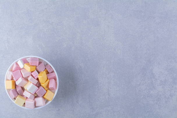 Fehér tál rózsaszín és sárga édességgel Pastila. Kiváló minőségű fénykép - Fotó, kép