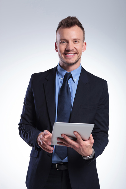 business man with tablet smiles at you - Photo, Image