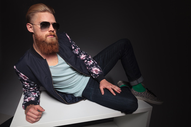 бородатий чоловік лежить на студійному столі
 - Фото, зображення