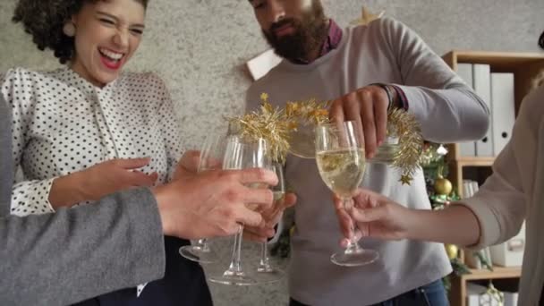 Grupo de jovens gerentes de escritório masculinos e femininos comemorando o Natal no trabalho, copos de champanhe e sorrindo alegremente, visão de baixo ângulo - Filmagem, Vídeo