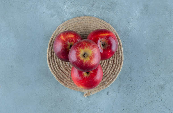 大理石の背景に、トリベット上の赤いリンゴ。高品質の写真 - 写真・画像