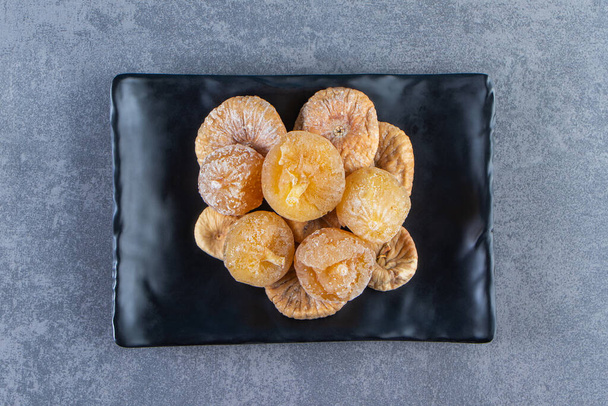 Various dried fruits in a bowl on a trivet , on the marble background. High quality photo - Photo, Image