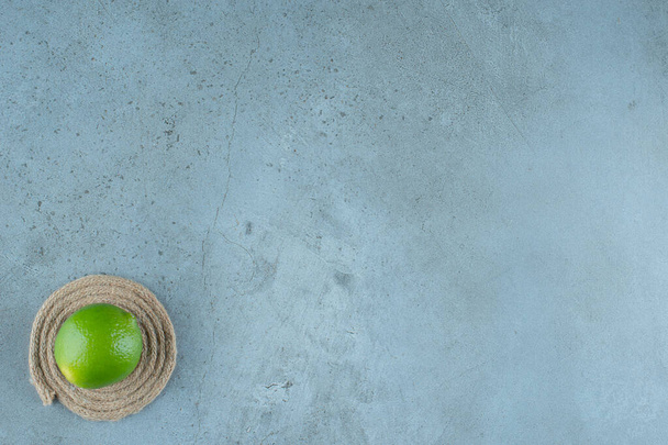 Flavorful, green lemon on a trivet , on the marble background. High quality photo - Photo, Image