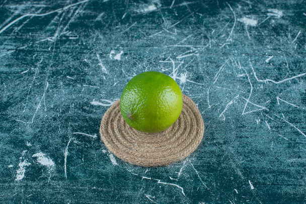Πράσινο λεμόνι σ 'ένα μπαστουνάκι, στο μαρμάρινο φόντο. Υψηλής ποιότητας φωτογραφία - Φωτογραφία, εικόνα