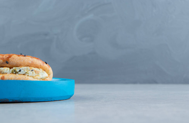 Maukkaita leivonnaisia juustolla sinisellä lautasella. Laadukas kuva - Valokuva, kuva