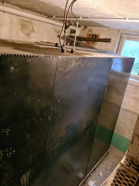 Kirli ve nemli bodrumda eski bir ısıtma tankı.. - Fotoğraf, Görsel