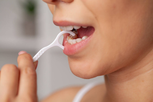 Гигиена полости рта и здравоохранение, улыбающиеся женщины используют зубную нить белые здоровые зубы. - Фото, изображение