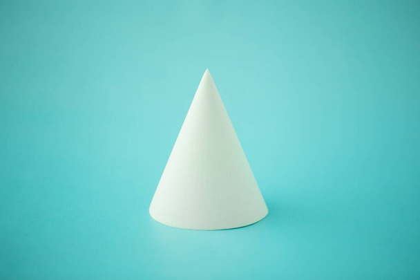 minimalism, geometric white cone on turquoise background, close-up - Photo, Image