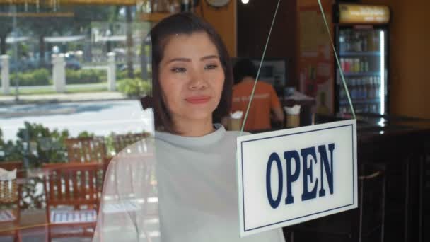 アジアの女性バーの所有者を開くからバーのウィンドウで閉じるには、道路上のトラフィックと背を向けてサインを逆にします。 - 映像、動画