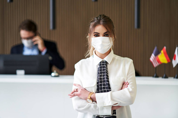 Receptionist wearing mask working in a hotel - Photo, Image