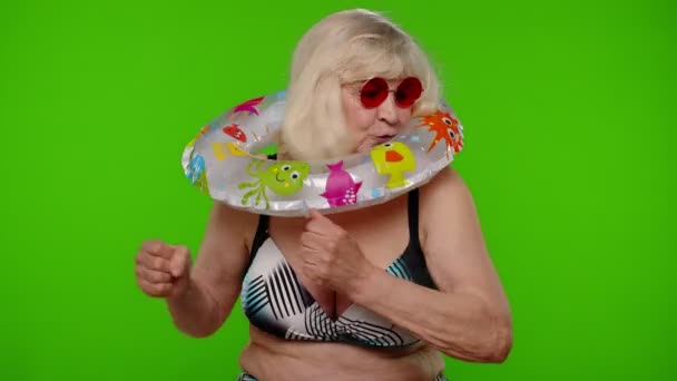 Mujer madura viajera bailando, celebrando, posando con anillo de goma en sujetador de traje de baño en croma key - Metraje, vídeo