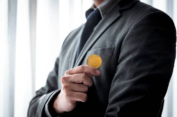 Бізнесмен, що показує золоті монети з символом Bitcoin
 - Фото, зображення