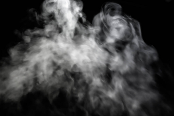 Белый дым светится в темноте, токсичный дым формирует свободные формы, красивые абстрактные абстракции на черном фоне, используемые для заднего плана.  - Фото, изображение