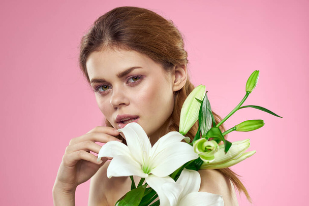 Portrait de femme aux fleurs blanches beau visage rose fond épaules nues - Photo, image
