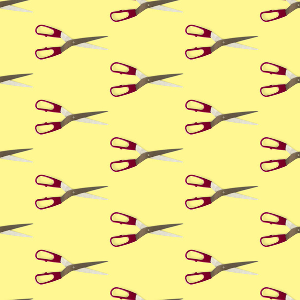 Patrón sin costuras de tijeras separadas de la capa plana amarilla. Tijeras con asa roja - Foto, Imagen