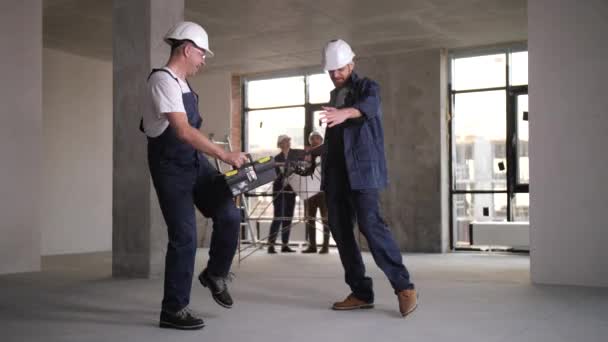 Cheerful workers dancing during renovation work - Záběry, video