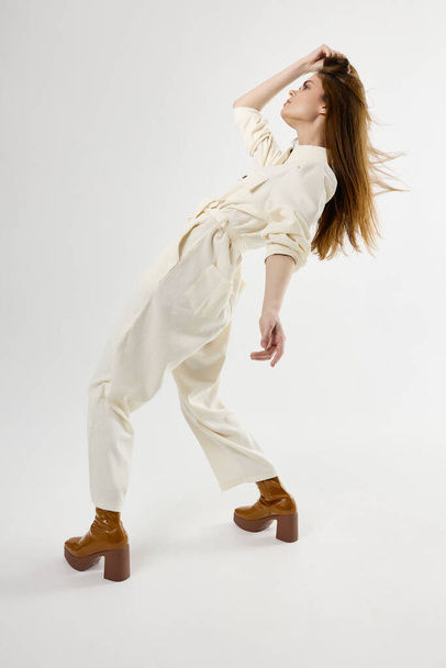 stylish woman in white jumpsuit fashion leaned back holding her hair - Foto, immagini