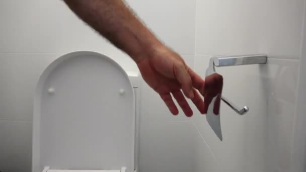 Persoon veranderende wc-papier op een toiletrolhouder in de overoriëntatie thuis toilet. - Video